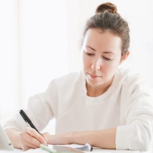 learning concept, young woman studying with a tablet, writing down the notes-6080191.jpg